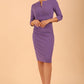 model wearing diva catwalk donna pencil dress in colour purple with wide band and sleeves and rounded neckline with low split in front