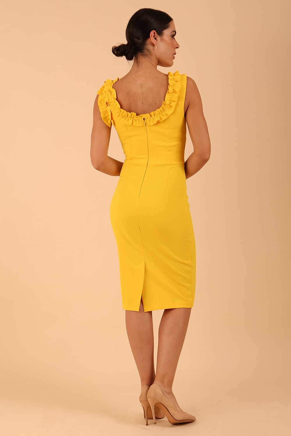 brunette model is wearing diva catwalk odessa pencil sleeveless dress with frill detail on rounded neckline in freesia yellow back