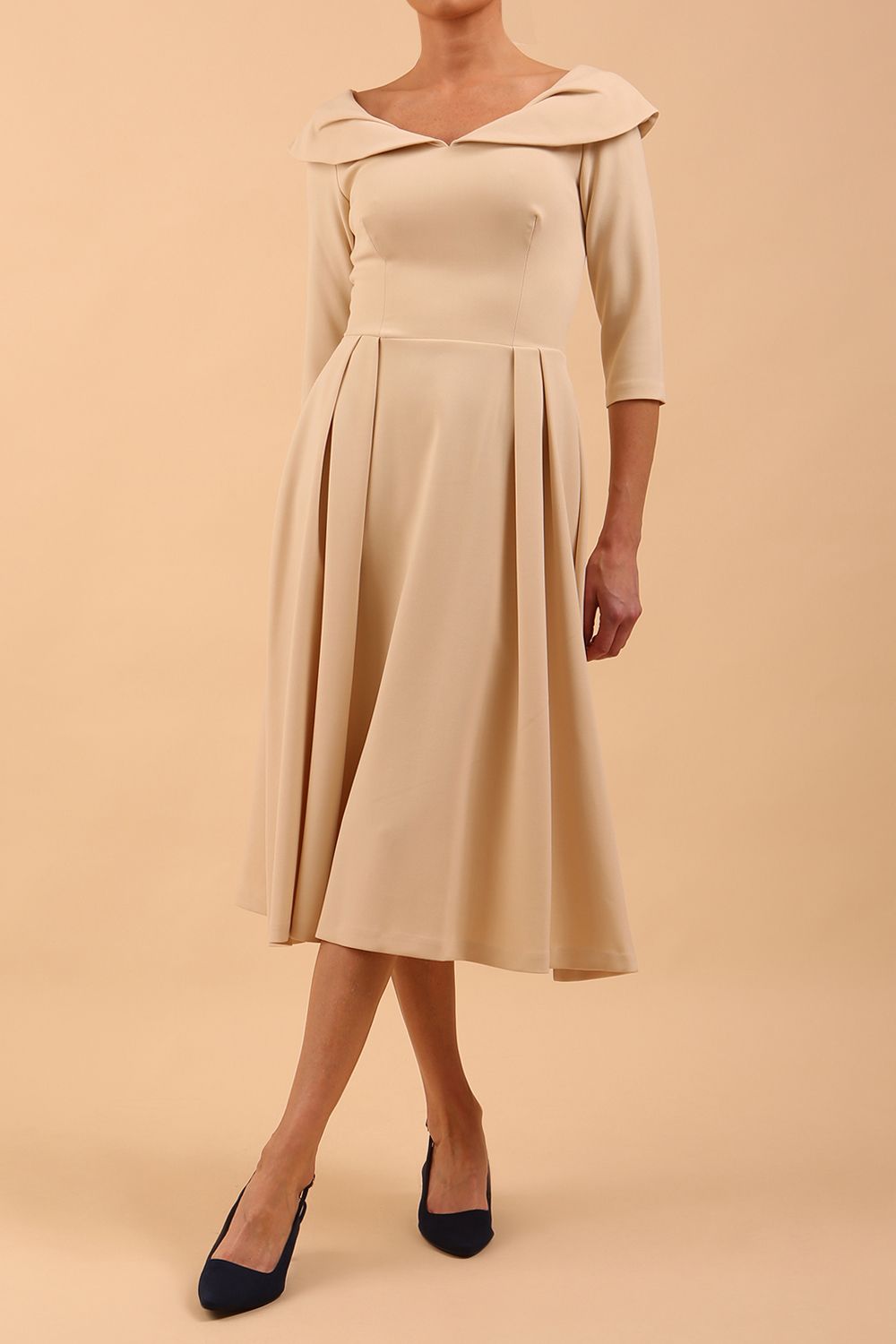 Model wearing Diva Catwalk Chesterton Sleeved dress with oversized collar detail and a-line swing pleated skirt in colour sandshell beige front