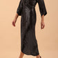 Brunette model wearing diva catwalk Glitterati Midaxi Sparkle Dress in Black in Jersey sparkle and ITY lining with wrap dress style and 3/4 length bell sleeves front side