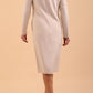 brunette model wearing diva catwalk cora white pencil dress with long sleeves and rounded neckline with pockets in colour sandy cream on back