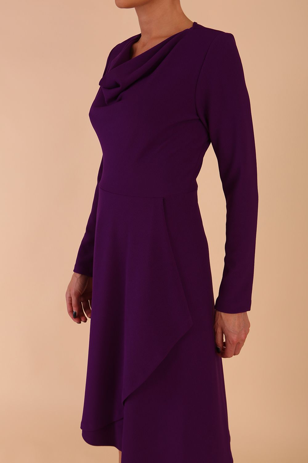model is wearing diva catwalk moraig swing long sleeve dress with high cowl neckline and wrap skirt in deep purple front side detail