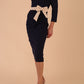 Model wearing a diva catwalk Brittany Off Shoulder Bow detail Pencil Dress with 3/4 sleeves and knee length in Navy Blue and Sandshell Beige colour front side 