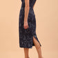 A model wearing a off shoulder pencil dress in Metallic Floral Jacquard and Mirage fabric in navy blue colour back