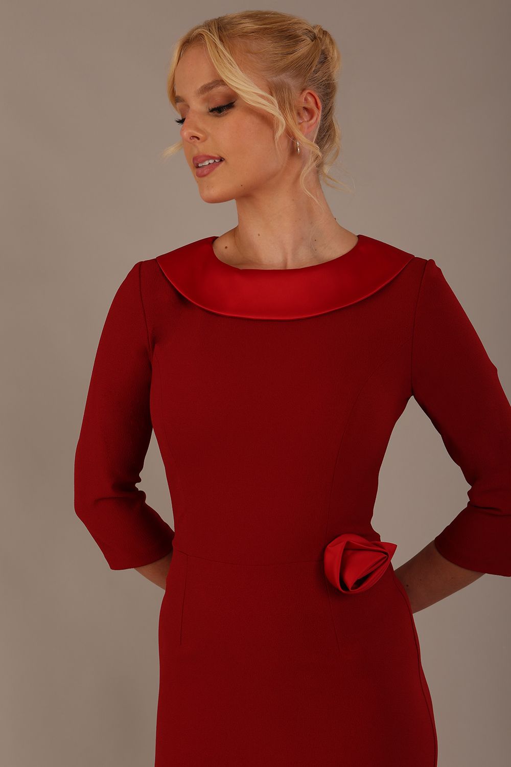 Woman wearing a Heathcote Floral Detail Pencil Dress with a plain background in rosewood red close up view