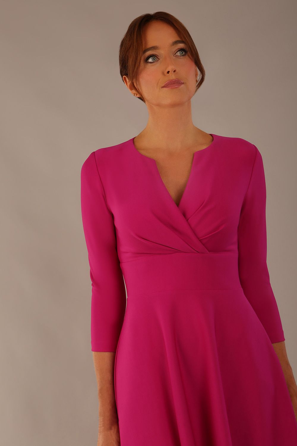 brunette model is wearing a diva catwalk Haddington sleeved A-line Dress knee length round neckline with crossover v-slit detail in magenta colour front image close up