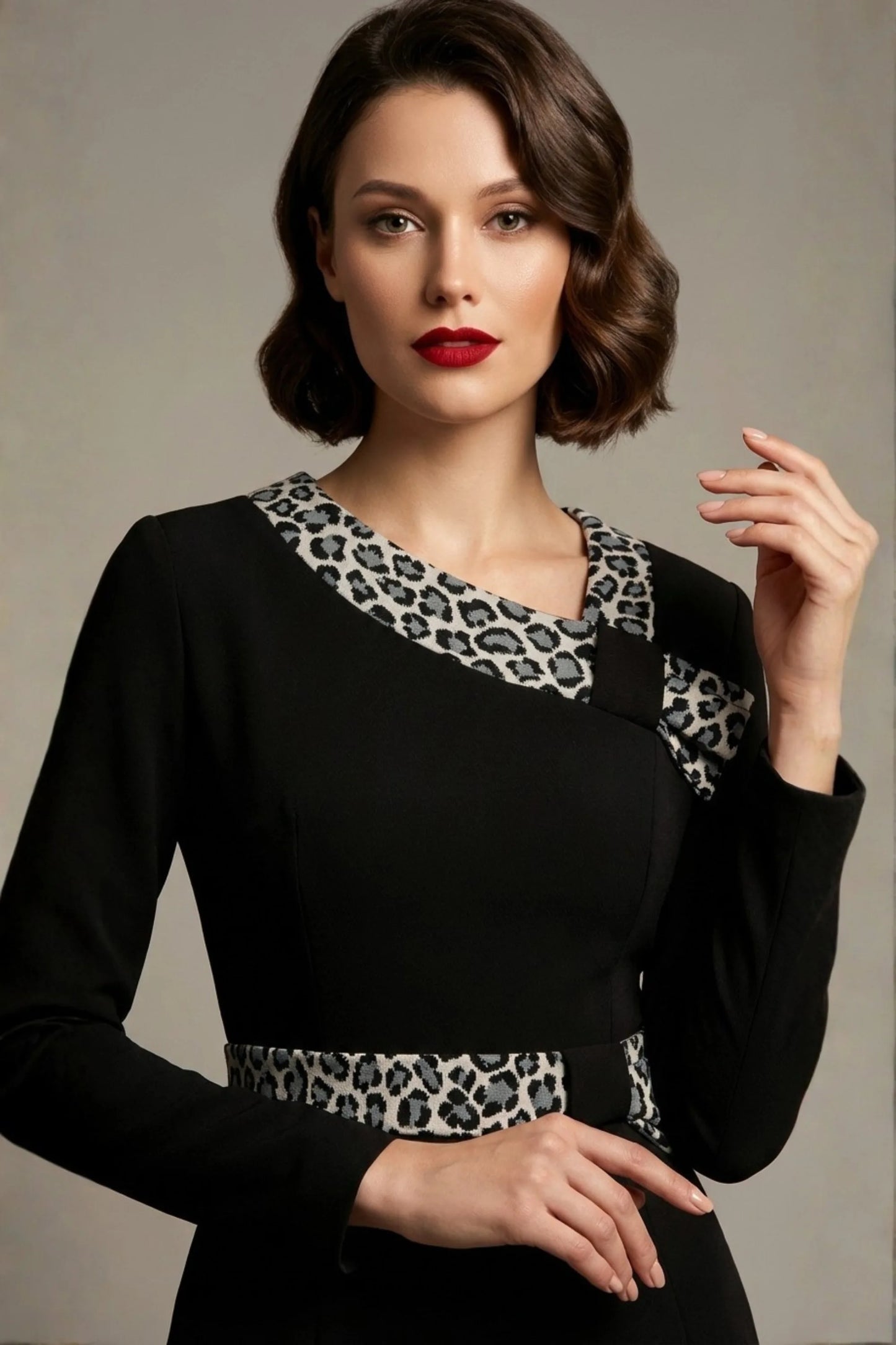 Model exuding vintage 1950s glamour in the black Hettie pencil dress, highlighting the plush animal print asymmetric collar and waistband (Black / Leopard Print Contrast)