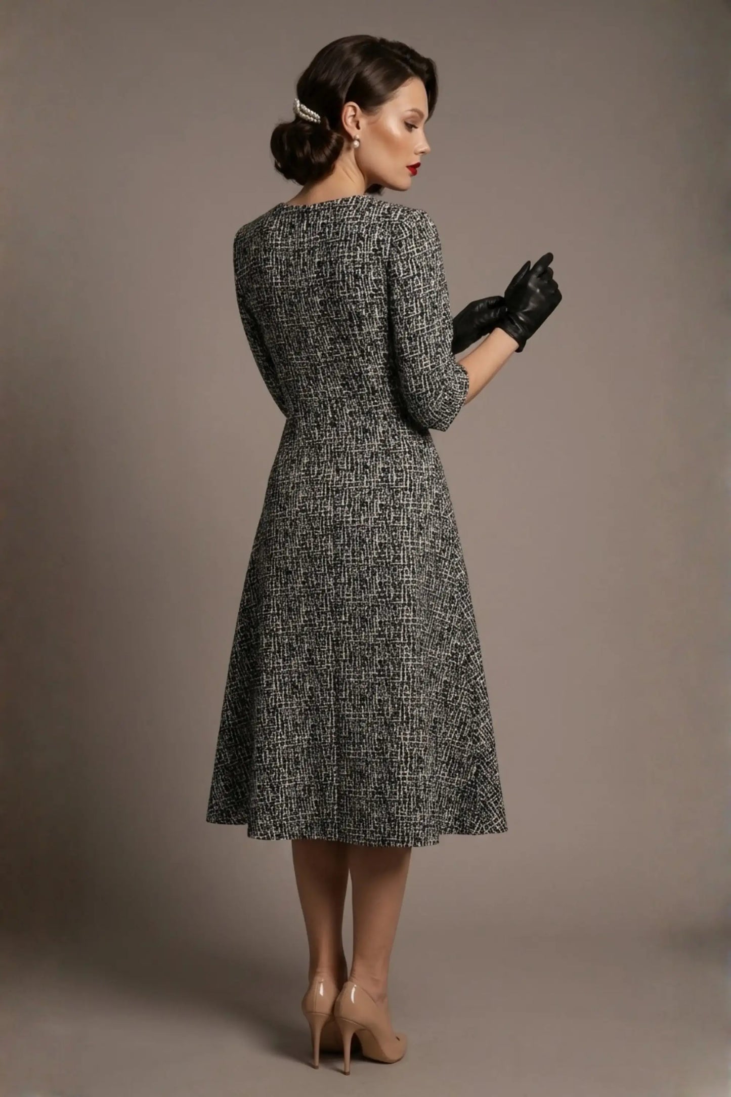 A model exuding classic glamour in the Darcie vintage-inspired A-line midi dress, showcasing the black and white crinkled jacquard and tailored fit (Abstract Crinkled)