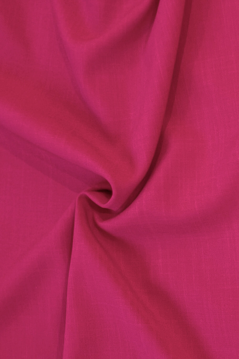A close-up of draped bright pink fabric with soft folds and a subtle woven texture.