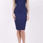 blonde model is wearing diva catwalk vivian sleeveless pencil skirt dress with overlapped bust area and lowered neckline in navy blue colour front