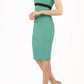 brunette model wearing diva catwalk nadia sleeveless pencil dress in emerald green colour with a contrasting black band and exposed zip at the back with a rounded neckline with a slit  in the middle front