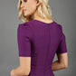 blonde model wearing seed belgravia square neckline purple pencil dress with short pleated sleeves and folded pleating at the front back