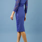 model is wearing diva catwalk bucklebury lace dress with sleeved and low neckline in riviera blue back
