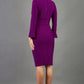 model is wearing diva catwalk fifi pencil skirt dress with three quarter flute sleeve and rounded neckline with a cut out at the front in purple  back image
