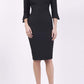 blonde model wearing seed tuscany pencil fitted dress in black colour with a split in the neckline and split detail on sleeves front