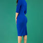 model is wearing diva catwalk pinhoe pencil dress with sleeved and high neckline with a keyhole detail in the middle and pleating across the tummy area in royal blue back