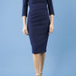 model is wearing diva catwalk quatro sleeved pencil dress with asymmetric wide cut our neckline in navy blue front