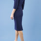 model is wearing diva catwalk quatro sleeved pencil dress with asymmetric wide cut our neckline in navy blue back
