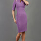 Model wearing Diva catwalk Derwent Pencil skirt dress with shoulder pads and short sleeves and pockets on both sides and empire waistline in purple heart front