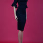 brunette model is wearing diva catwalk hollie pencil dress with frilled flute sleeve and low v-neck cut in black front