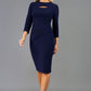 A blonde Model is wearing a cut out peep hole neckline pencil dress with pleating across the tummy area and 3/4 sleeve lenght sleeve in navy front image