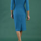 brunette model is wearing diva catwalk pencil dress with collar and a button detail on a side with 3/4 sleeve in mosaic blue back