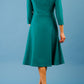 model is wearing diva catwalk palmerston vintage style a-line dress with sleeves and high neck with a slit in pacific green colour back