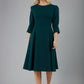 blonde model is wearing diva catwalk harpsden a-line skirt 3/4 sleeve swing dress with rounded neckline in forest green front
