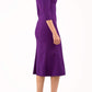 blonde model is wearing diva catwalk senne midaxi sleeved dress with fishtail and rounded neckline with a slit in the middle in royal purple side