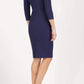 model wearing diva catwalk york pencil-skirt dress with sleeves and rounded folded collar and plearing across the tummy area in navy blue colour back