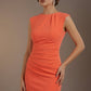 Woman wearing an orange dress against a brown background (Sea Coral)