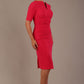 blonde model is wearing diva catwalk lydia short sleeve pencil fitted dress in paradise pink colour with rounded neckline with a slit in the middle front