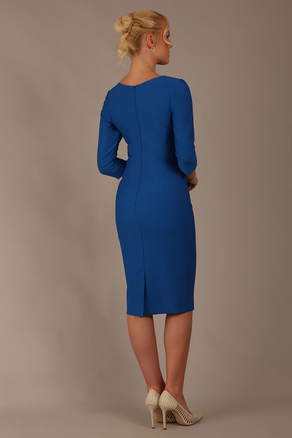 Woman wearing a diva catwalk Seed Greenwich Sleeved Pencil Dress in sapphire blue colour with a plain background back view
