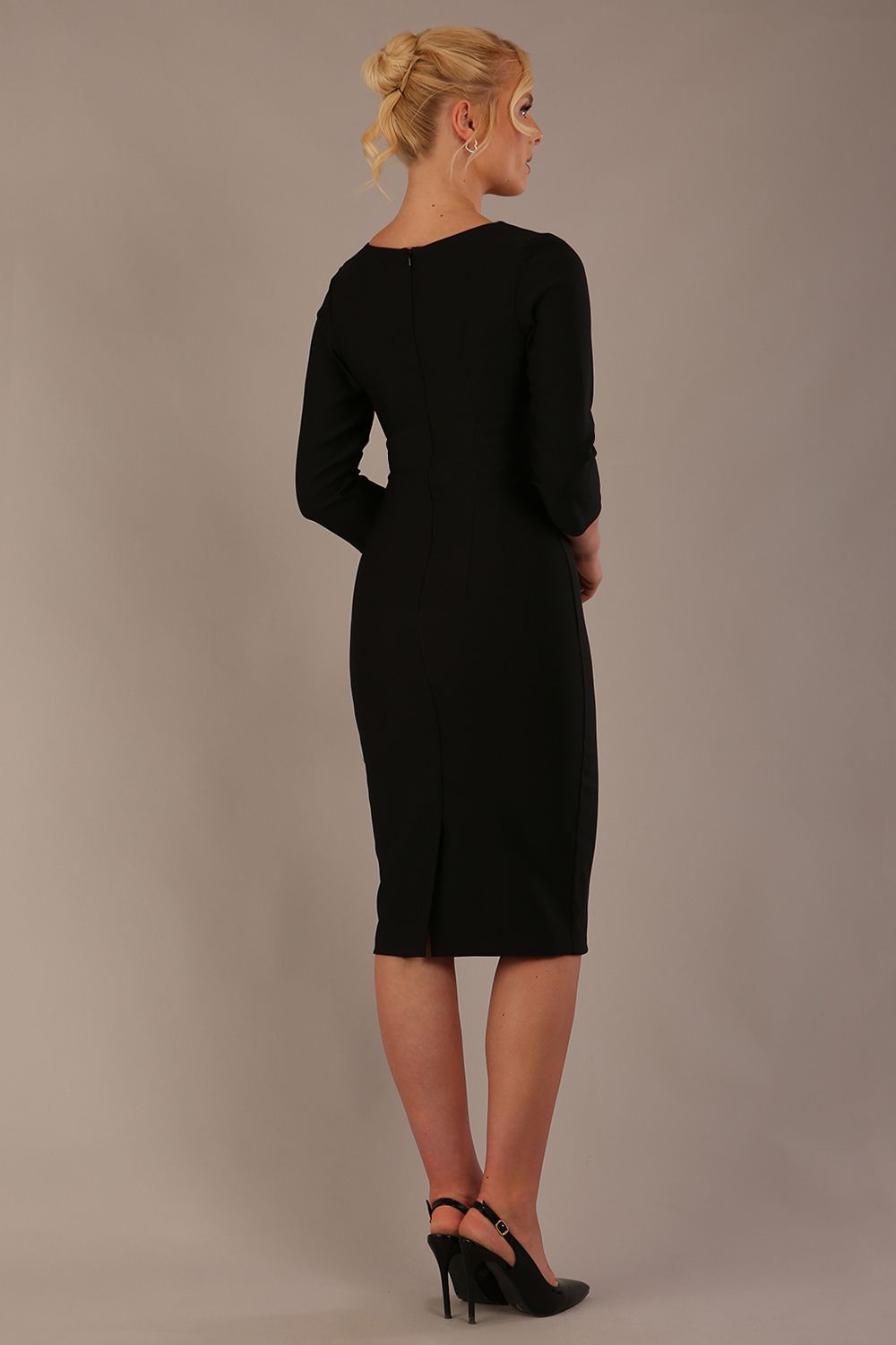 Woman wearing a diva catwalk Seed Greenwich Sleeved Pencil Dress in black colour with a plain background back view