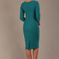 Woman wearing a diva catwalk Seed Greenwich Sleeved Pencil Dress in harbour green colour with a plain background back view