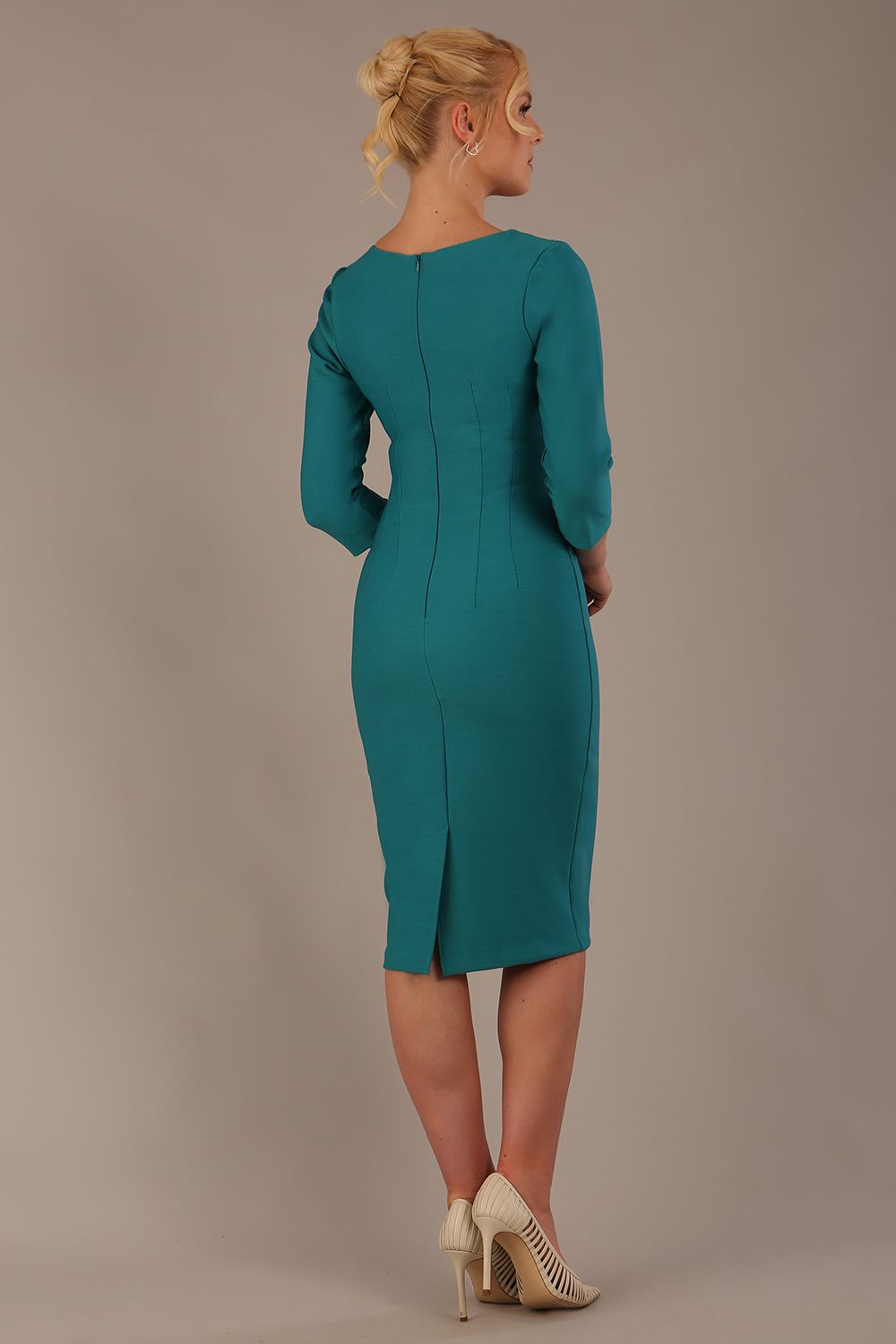 Woman wearing a diva catwalk Seed Greenwich Sleeved Pencil Dress in harbour green colour with a plain background back view