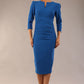 model is wearing a diva catwalk seed fitzrovia 3/4 sleeve pencil dress with round neckline and v-slit and pleating details on the skirt in sapphire blue front