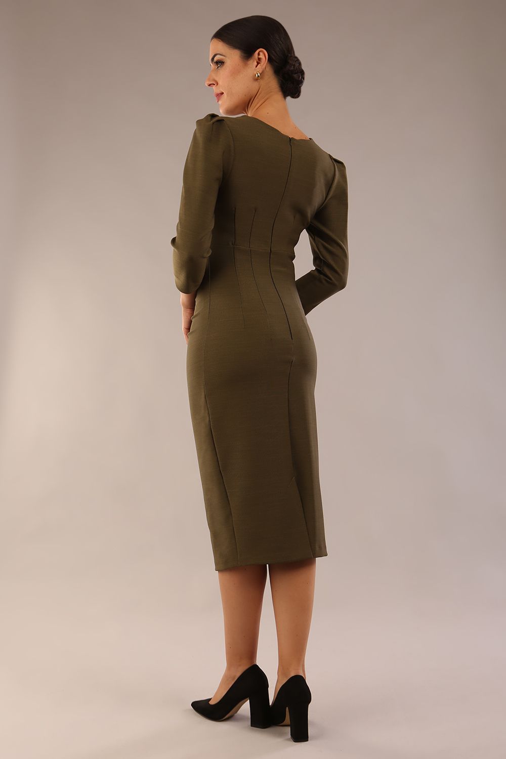 model is wearing a diva catwalk seed fitzrovia 3/4 sleeve pencil dress with round neckline and v-slit and pleating details on the skirt in Olive Green back