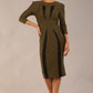 model wearing seed bertie dress with sleeves and rounded neckline with lace details pointing towards the band in olive green front