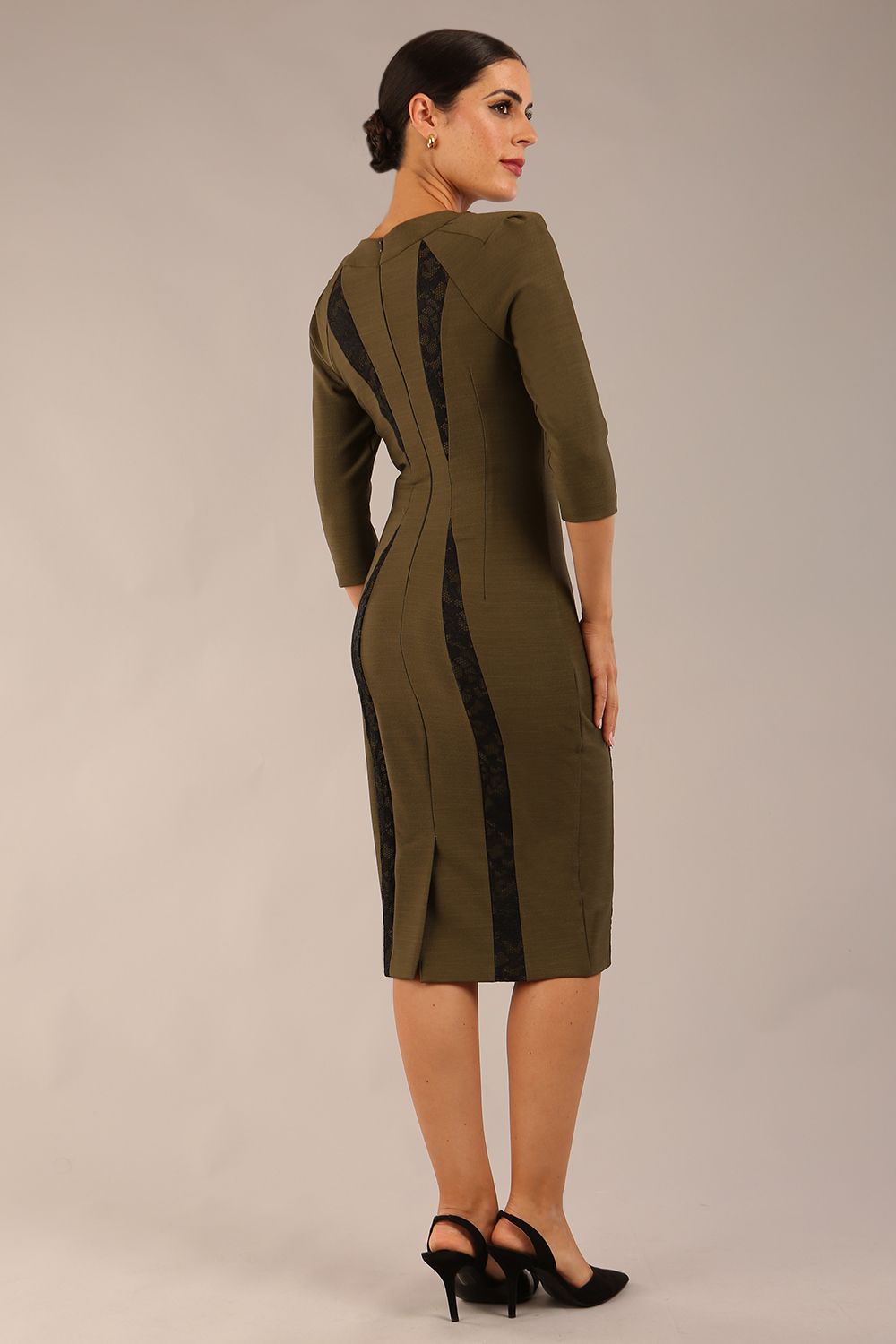 model wearing seed bertie dress with sleeves and rounded neckline with lace details pointing towards the band in olive green back