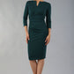 model wearing diva catwalk donna pencil dress with wide band and sleeves and rounded neckline with low split in forest green colour  front