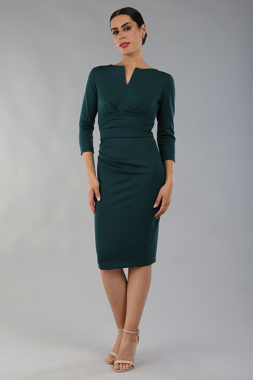 model wearing diva catwalk donna pencil dress with wide band and sleeves and rounded neckline with low split in forest green colour  front