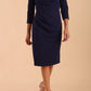 model wearing diva catwalk donna pencil dress with wide band and sleeves and rounded neckline with low split in navy blue colour front
