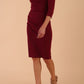 model wearing diva catwalk donna pencil dress in burgundy colour with wide band and sleeves and rounded neckline with low split in front