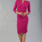 model wearing diva catwalk donna pencil dress with wide band and sleeves and rounded neckline with low split in Magenta colour front side