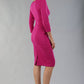 model wearing diva catwalk donna pencil dress with wide band and sleeves and rounded neckline with low split in Magenta colour back side