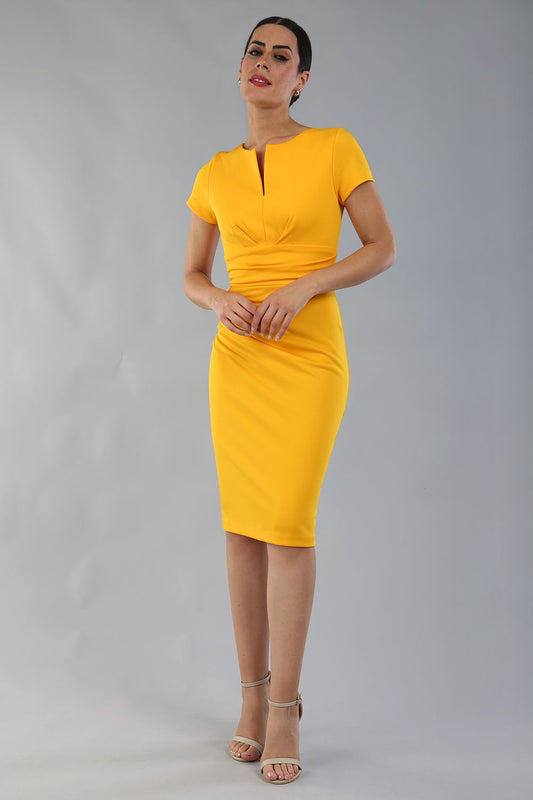 Model wearing Diva Catwalk Donna Short Sleeve Pencil Dress with a wide band and pleating across the tummy area in Saffron Yellow  front