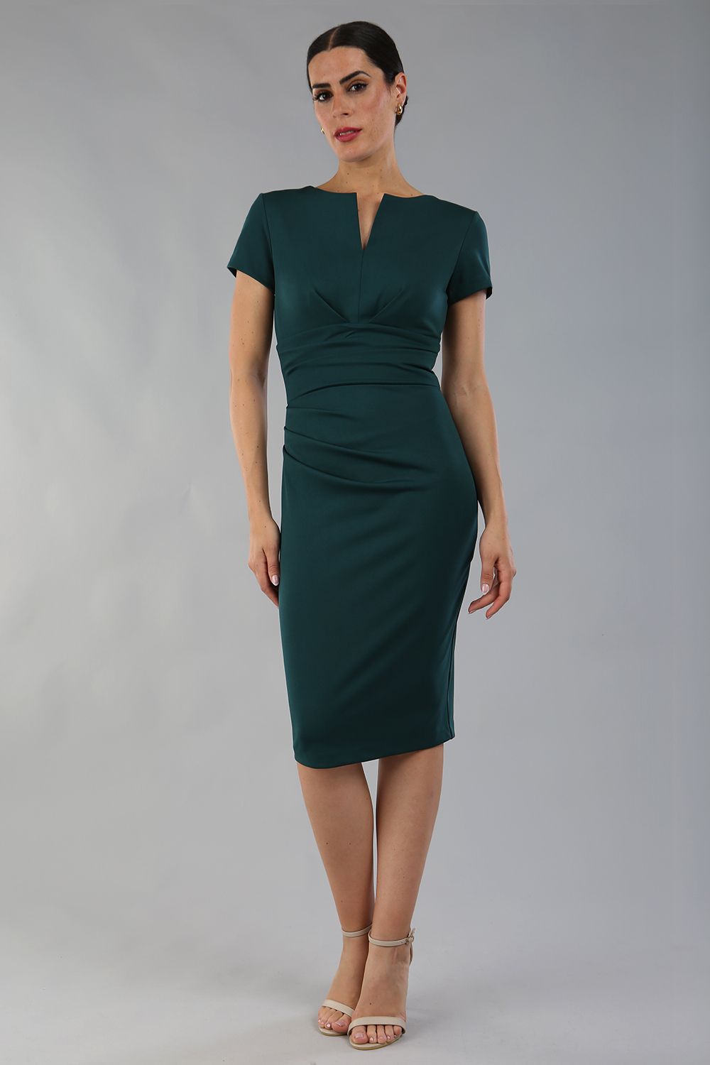 Model wearing Diva Catwalk Donna Short Sleeve Pencil Dress with a wide band and pleating across the tummy area in Forest Green  front