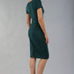 Model wearing Diva Catwalk Donna Short Sleeve Pencil Dress with a wide band and pleating across the tummy area in Forest Green back