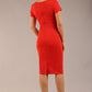 Brunette Model wearing a Diva Catwalk Donna Short Sleeve Pencil Dress with a wide band and pleating across the tummy area and round neckline with v-slit in Burnt Orange back image